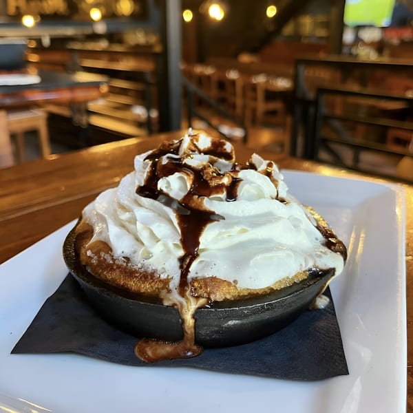 Skillet cookie topped with whipped cream and chocolate sauce, served at Hawk N Dove.
